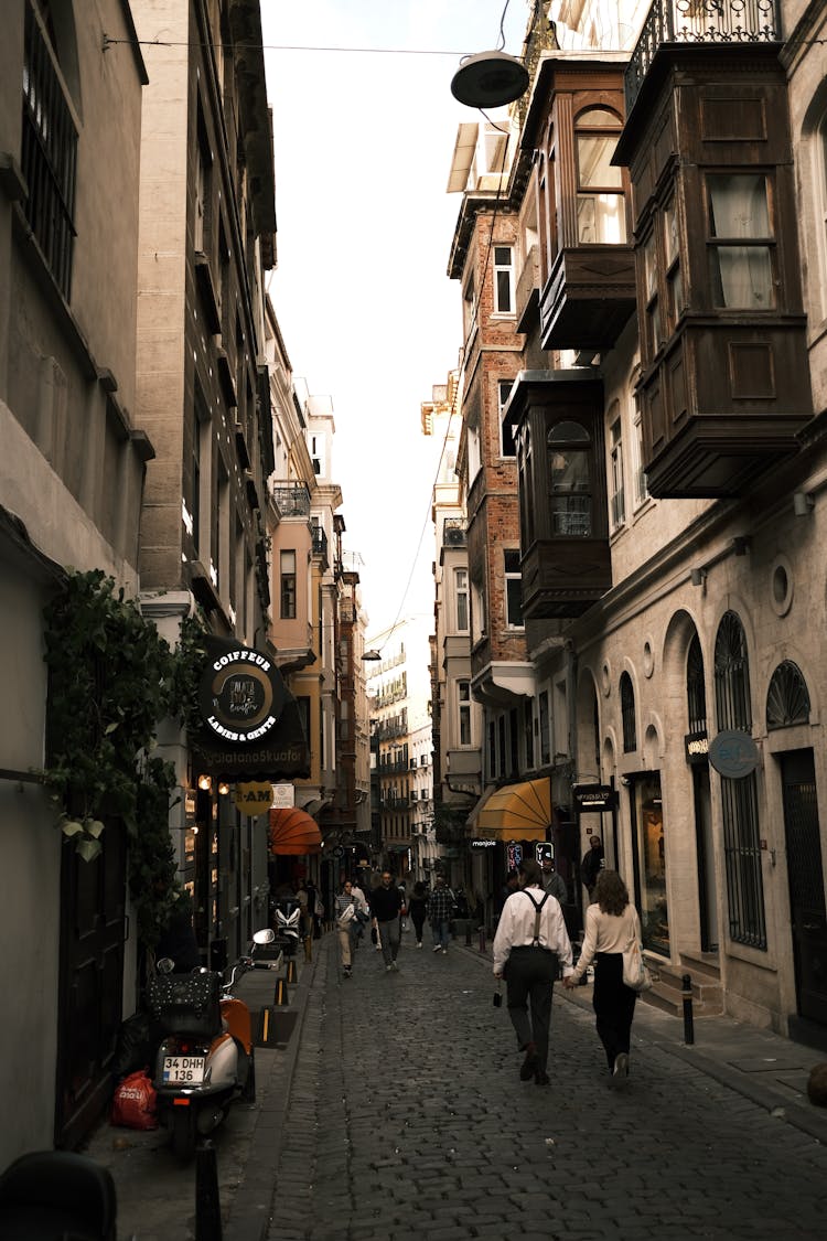 People Walking On The Street Between Apartment Buildings