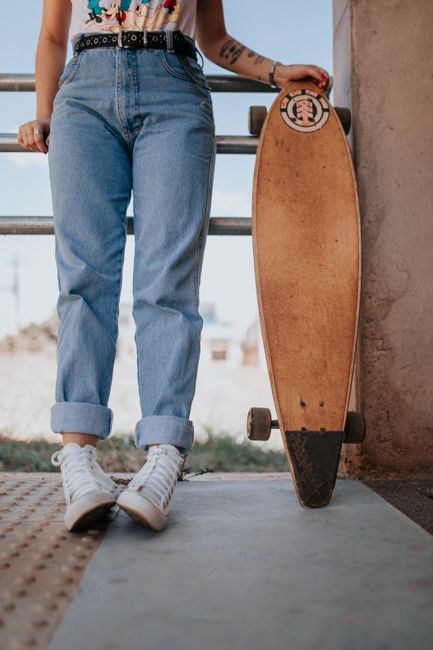 Casual style skater holding longboard, showcasing street fashion in Cascavel, Brazil.