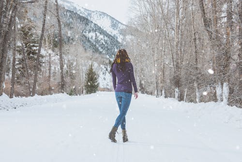 Woman in Purple Sweater Standing on Snow