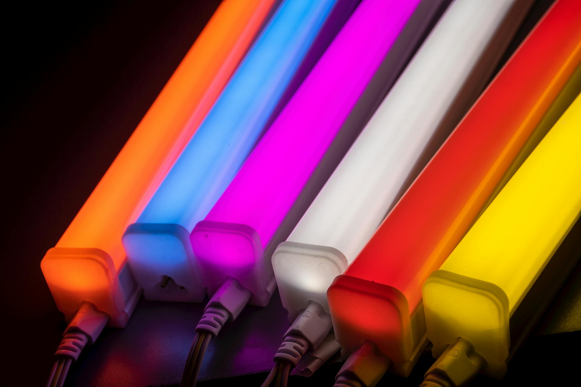 Close-up photo of colorful illuminated LED light tubes arranged in a rainbow pattern.