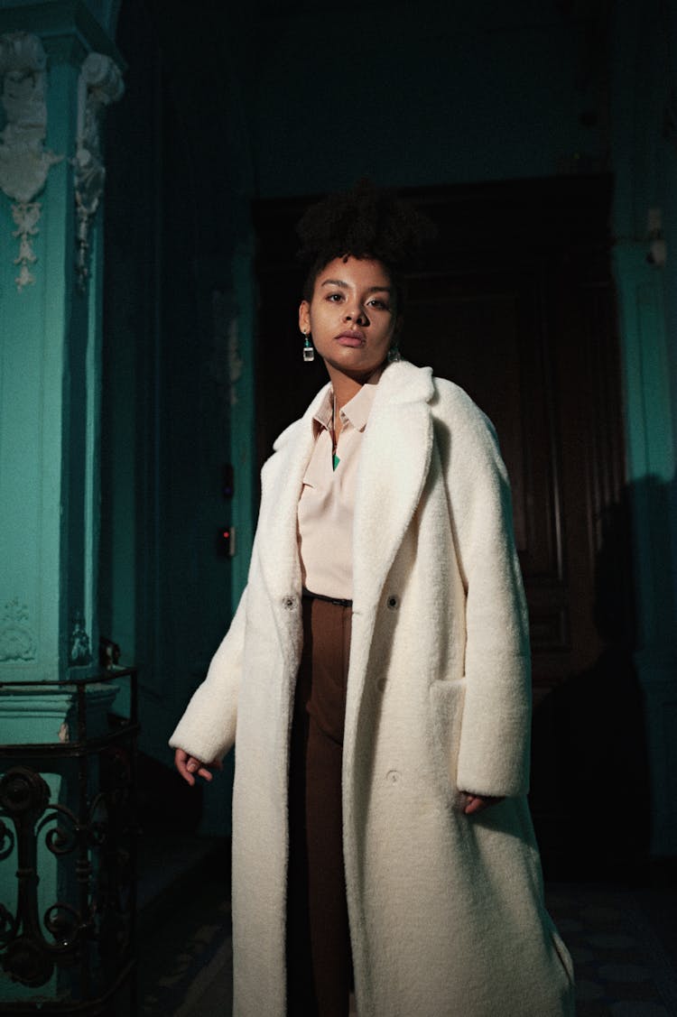 Woman In Winter Coat Standing In Dark Corridor