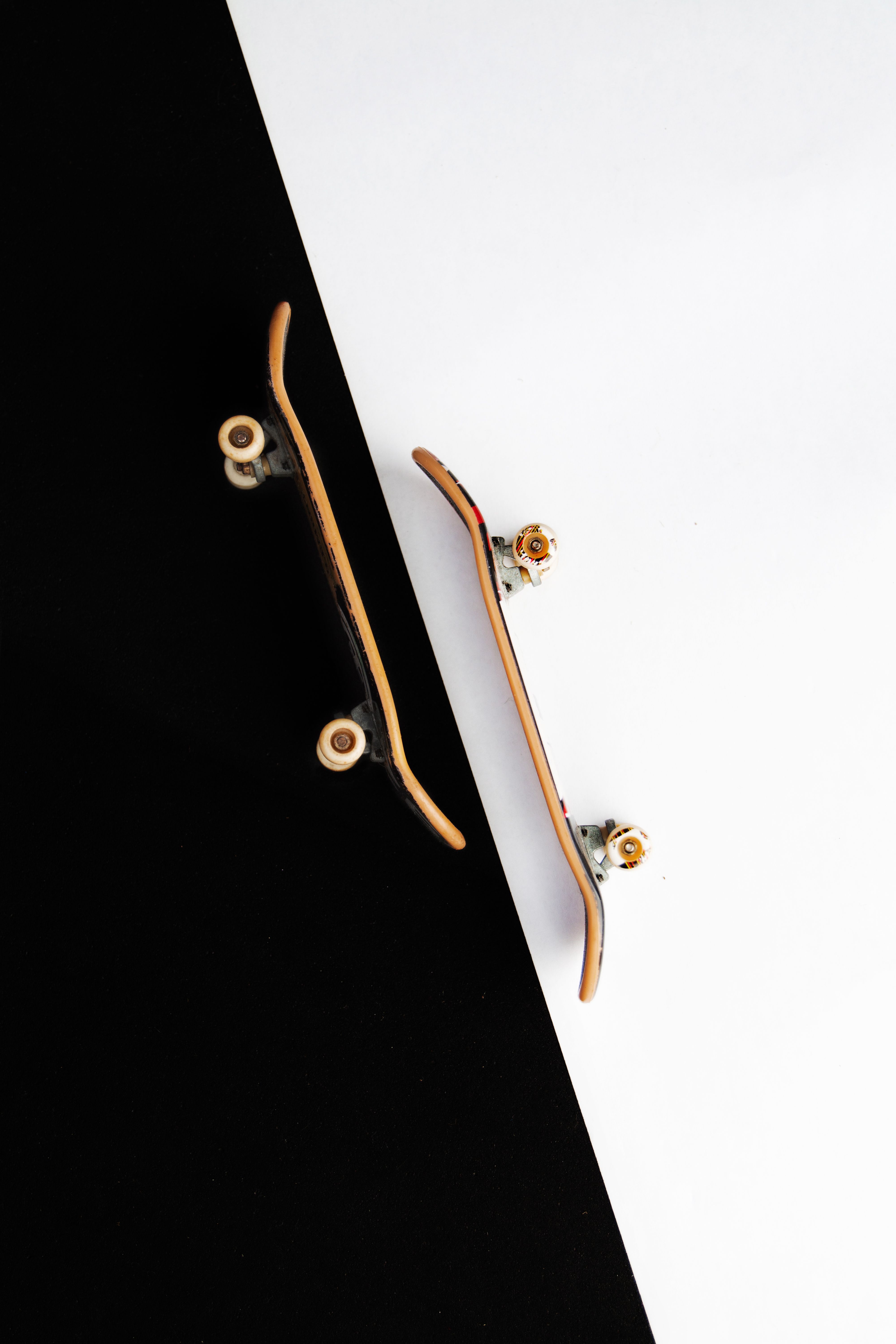 High-contrast minimalist photo showcasing two miniature skateboards on a black and white background.