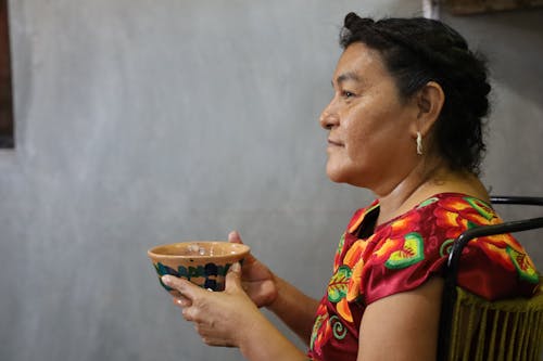 A Side View of a Woman Holding a Ceramic Bowl