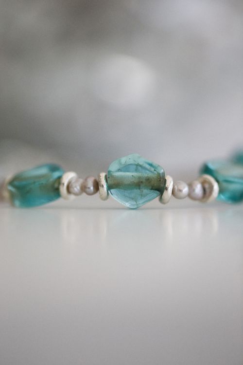 Free Close-up of a beaded bracelet with turquoise gems on a gray background. Stock Photo