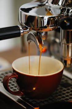 A detailed shot of an espresso machine pouring coffee into a cup, emphasizing the brewing process.