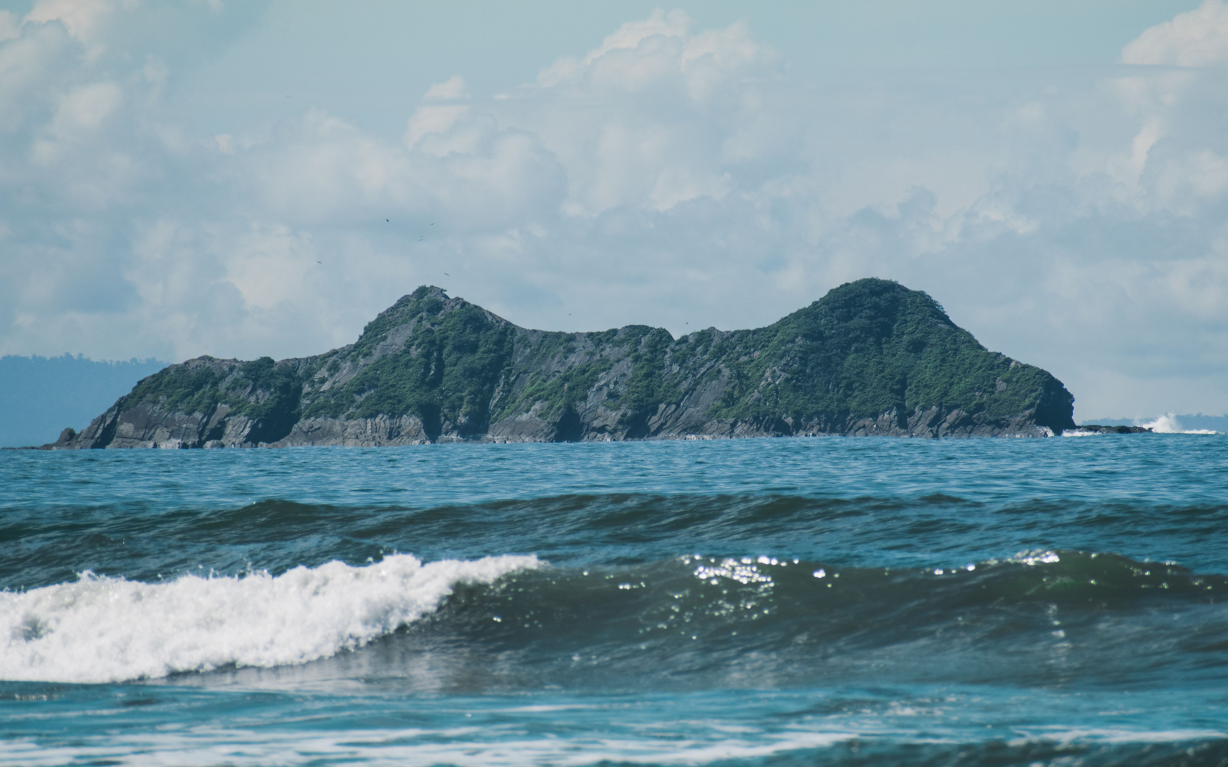 Waves crashing on the shore with Uvita Island in the background