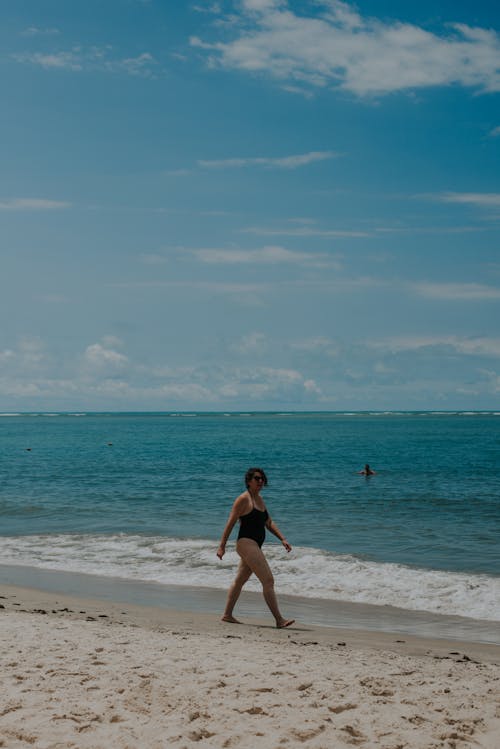 Woman in Black Swimsuit Walking on Beach