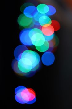 Colorful bokeh light circles on a black background, creating a vibrant and abstract effect.