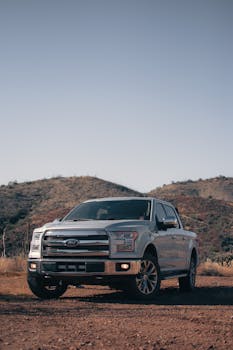 Silver Ford F-150 parked in Arizona's Superstition Mountains, showcasing rugged desert terrain.