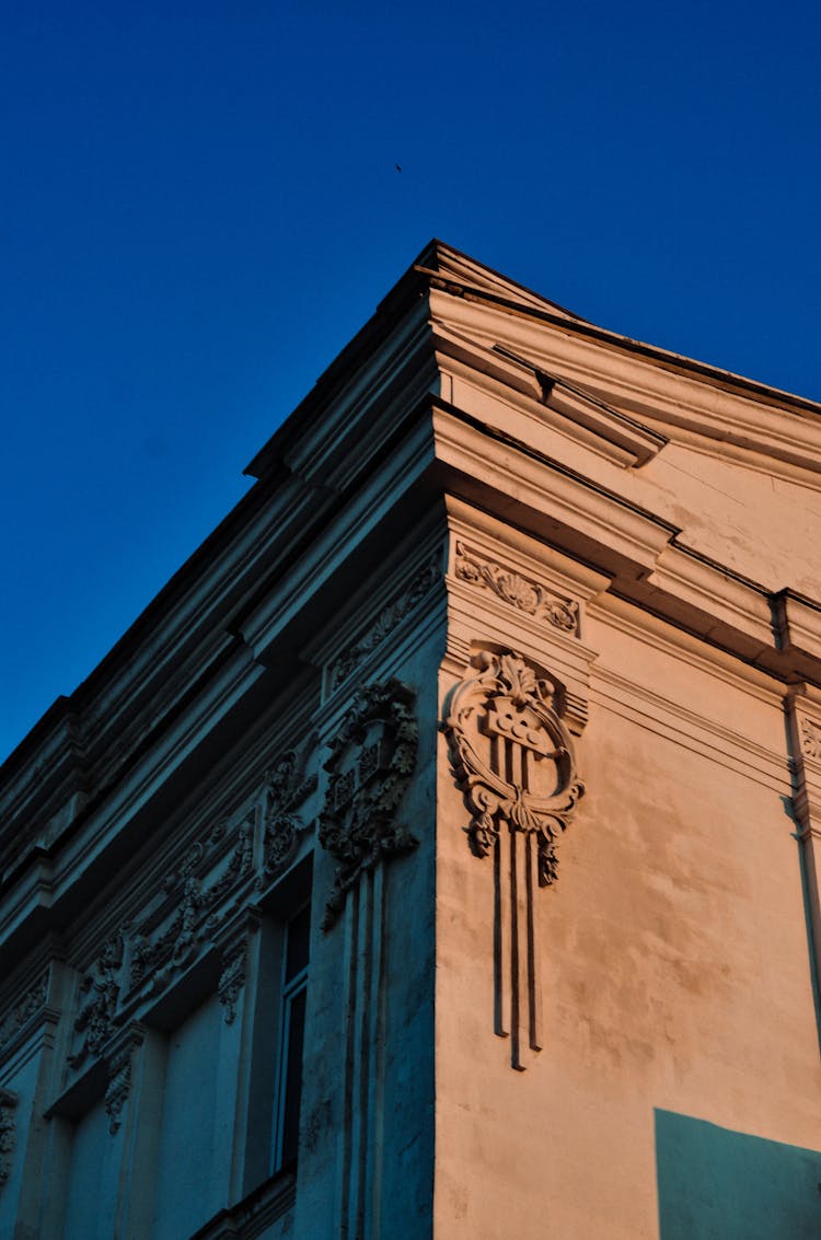 Low Angle Shot Of A Classical Building Corner Against Blue Sky