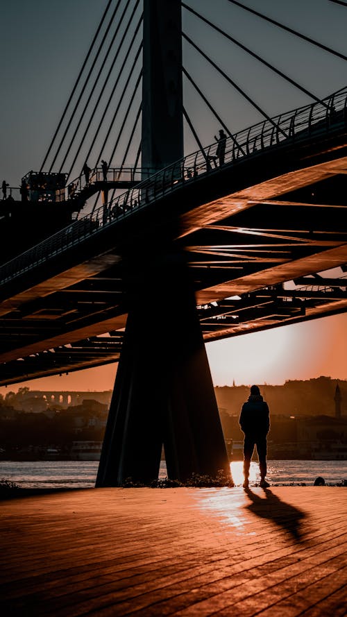 Person Standing under Halic Bridge at Sunset