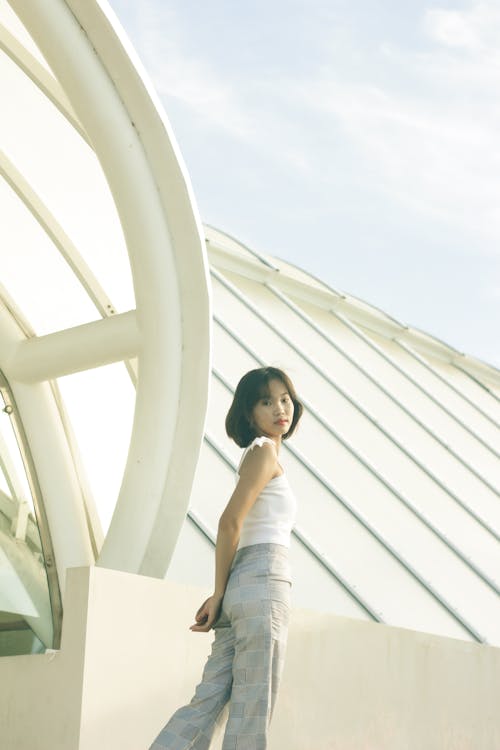 Free Young Woman Posing by a White Roof Stock Photo