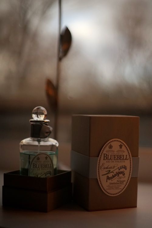 Free Close-up of a stylish glass perfume bottle with packaging in soft lighting. Stock Photo