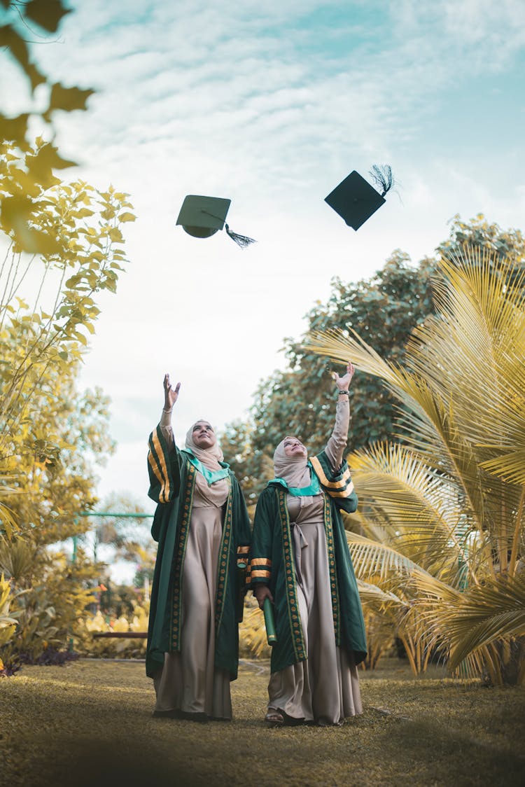 Women In Academic Dress Throwing Their Graduation Cap 