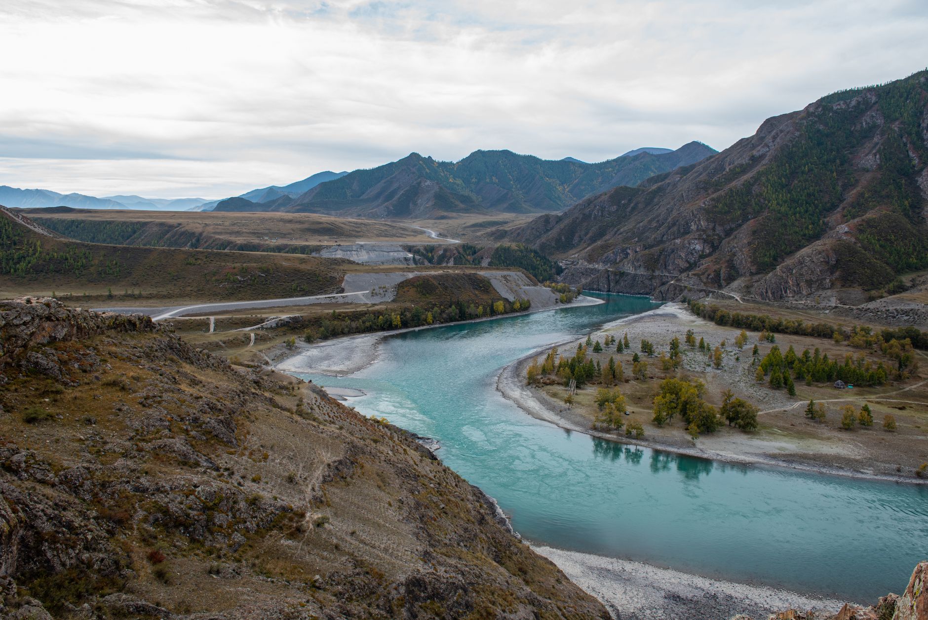 A breathtaking view of the winding river and mountains in Altai, Russia, capturing nature's serene beauty.