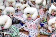 在充满活力的节日场景中，表演者们画着精致的脸谱，身着盛装，一同欢庆