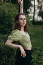 Woman in Green Knit Sweater and Black Denim Jeans Standing on Green Grass Field