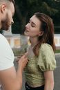 Man in White T-shirt Kissing Woman in Green Dress