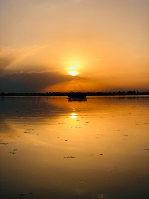 Free Captivating sunset over Dal Lake in Srinagar, reflecting golden hues on calm water. Stock Photo