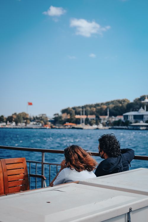 Free A couple enjoying a peaceful moment by the Bosphorus in Istanbul under a clear blue sky. Stock Photo