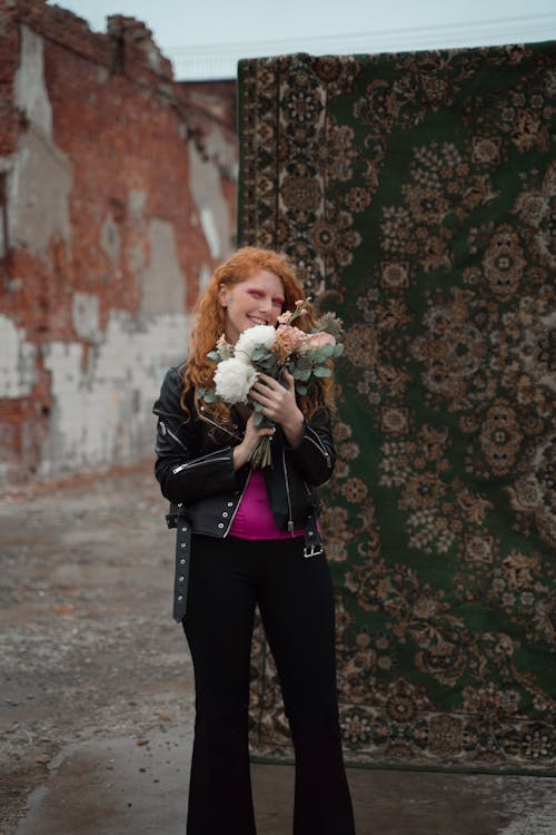 Woman with Flowers Standing near Carpet