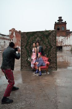 Stylish outdoor fashion photoshoot with models and photographer in urban setting.