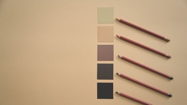 Flat lay of colored pencils and earthy tone swatches on a beige background, perfect for art and design contexts.. pexels, fla