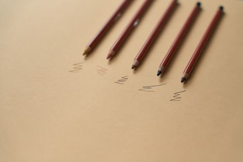 Free Artistic arrangement of colored pencils on paper with scribbles. Stock Photo