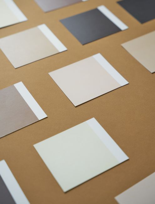 A minimalist display of assorted color swatches on a brown background, showcasing varied shades.