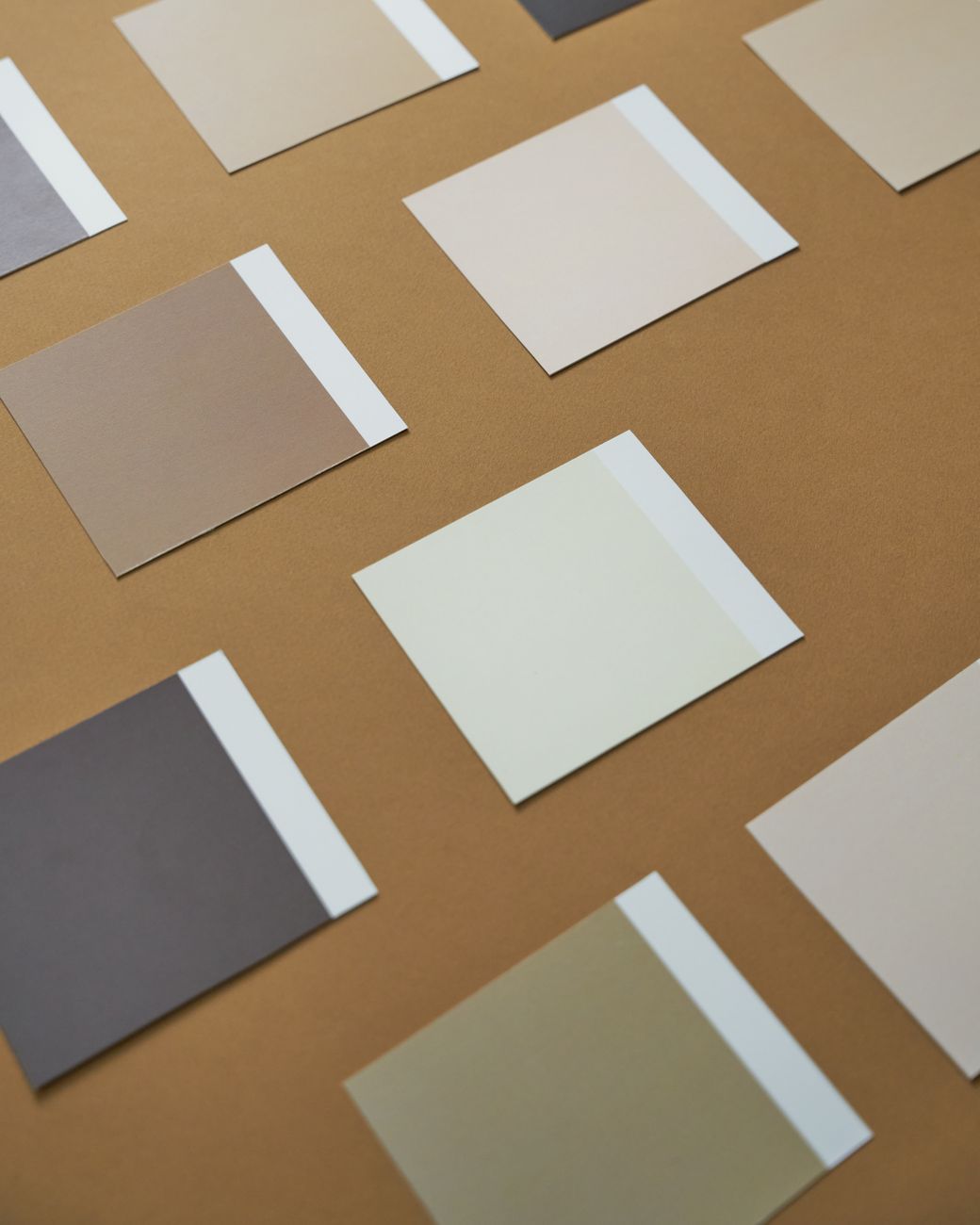 Collection of neutral color swatches on a brown paper background, arranged orderly.. collection, neutral, color