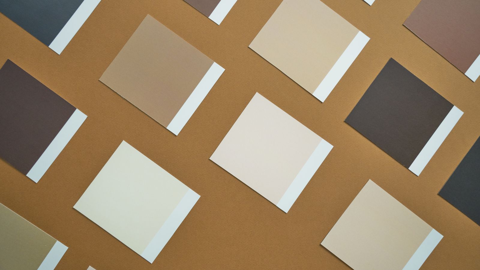 An arrangement of paint color swatches in warm neutral tones