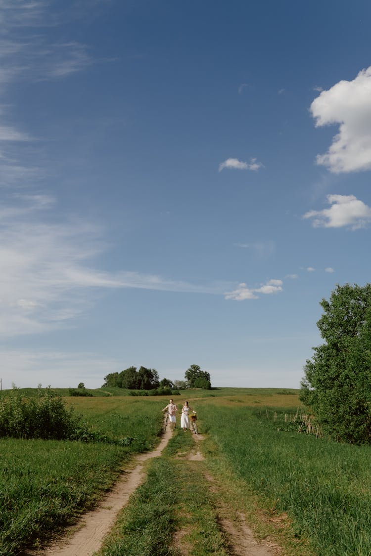 A Family Walking On A Track With Green Grass