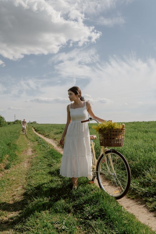 Woman Standing with Bicycle on Footpath