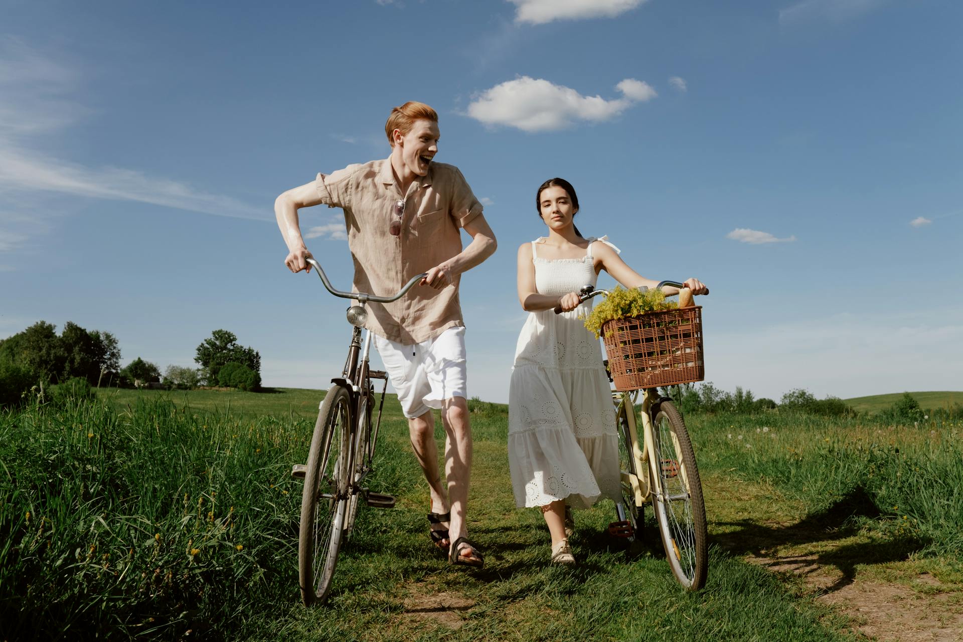 Man Smiling with Woman Leading Bicycles