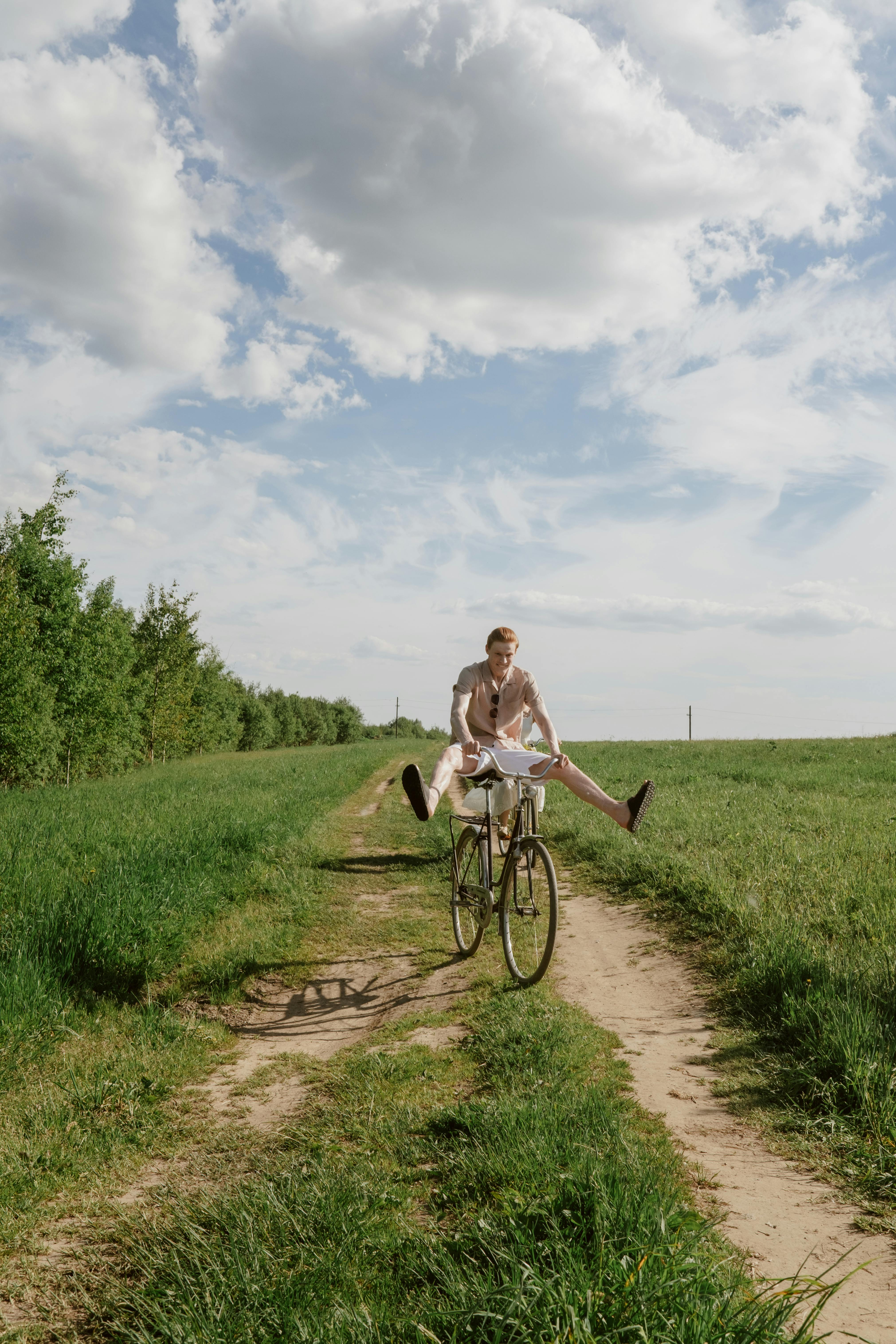 man riding bicycle on green grass field