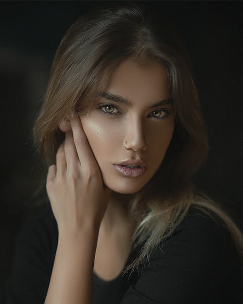 A Woman in Black Shirt with Her Hand on Her Face