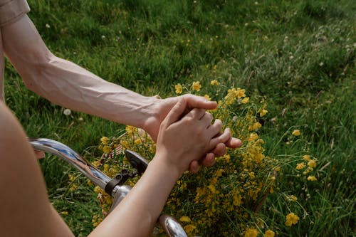 Man Holding Womans Hand over Flowers