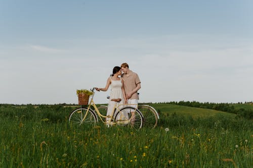 A Couple Looking at Each Other while Standing on the Field