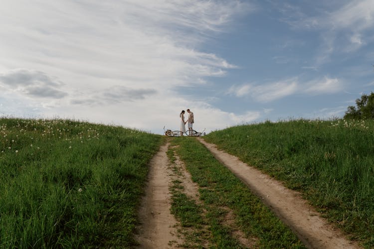 A Couple Standing On The Field