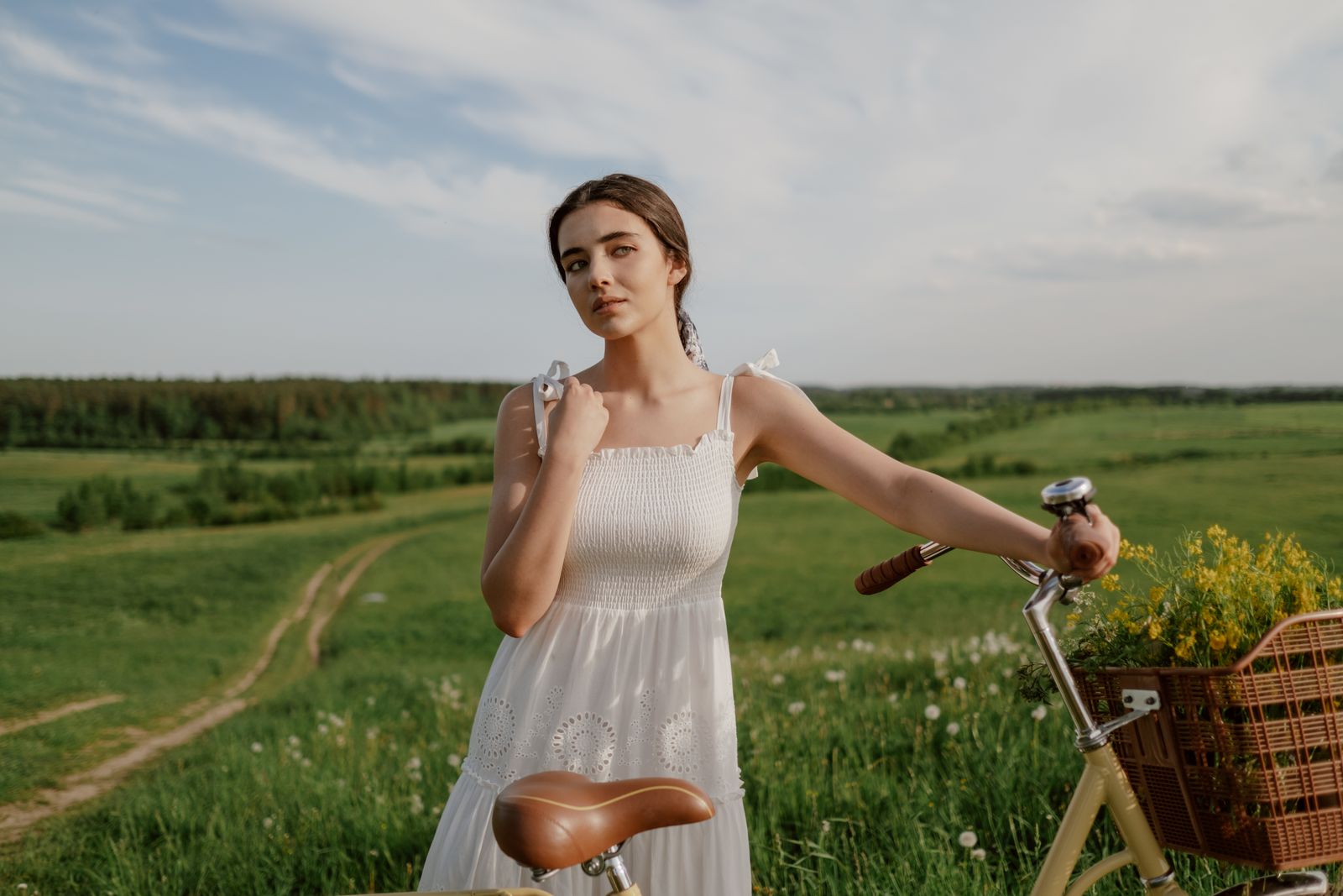 A woman in an effortless romantic dress riding a bicycle