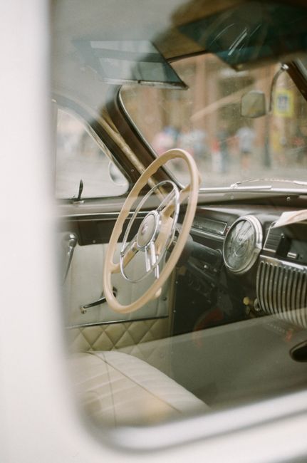 Explore this elegant vintage car interior featuring a classic steering wheel and dashboard.
