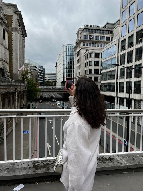 A Woman Taking a Picture in a City