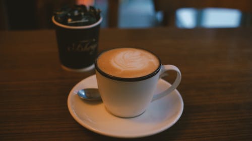 White Ceramic Mug With Coffee on Saucer With Spoon 