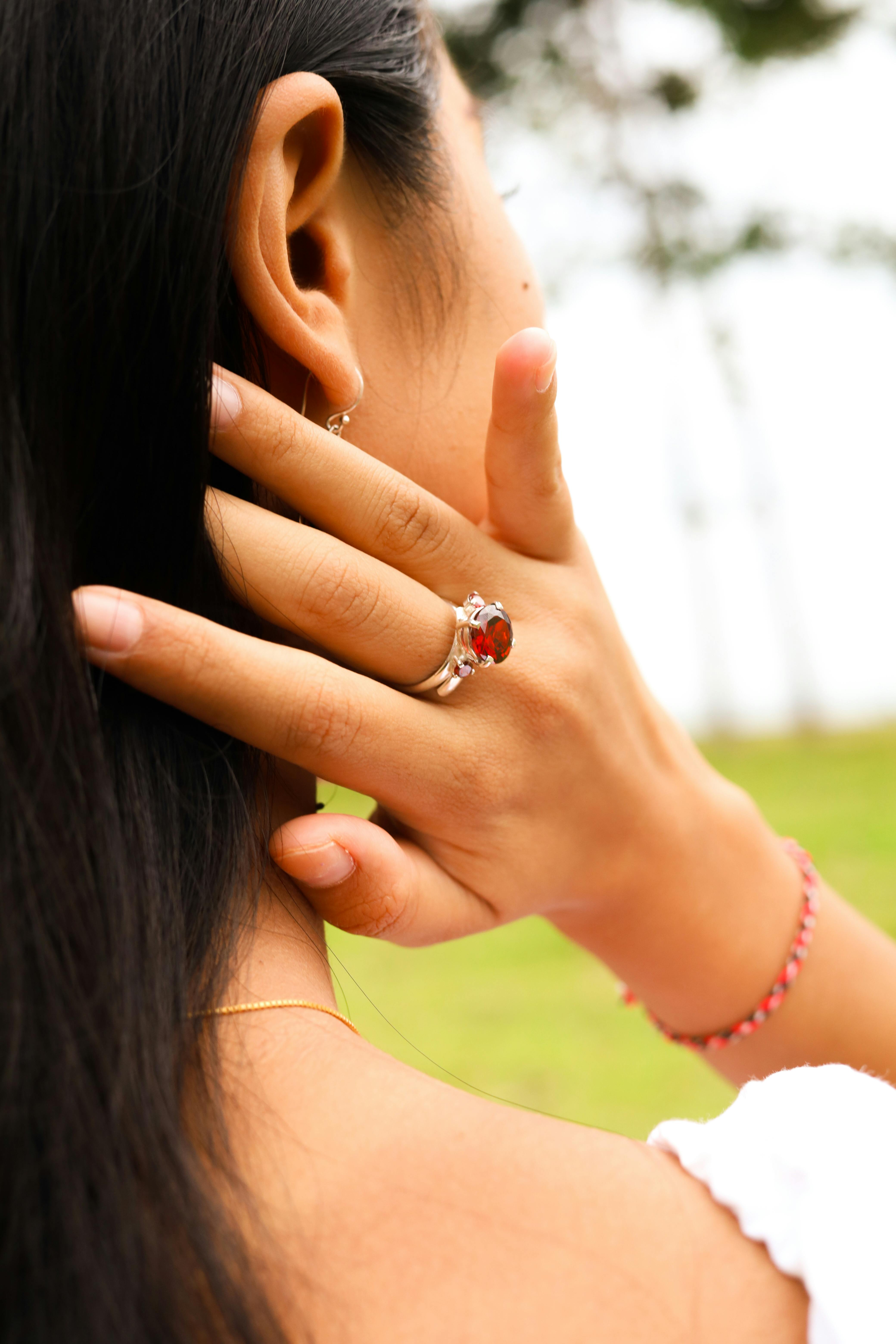 Hand Wearing Engagement Ring with Red Gem · Free Stock Photo