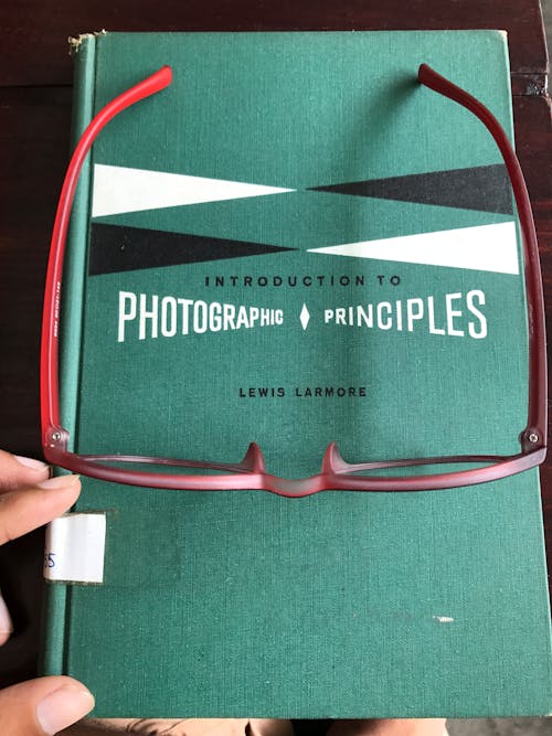 Gratis Kacamata Dengan Bingkai Merah Di Buku Biru Foto Stok