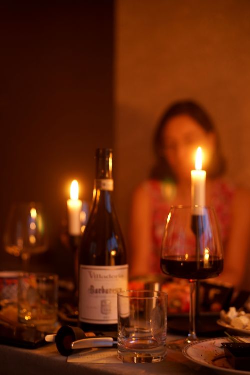Free Warm and intimate candlelit dinner setting with wine and blurred background. Stock Photo