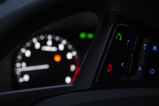 Close-up of a modern car dashboard displaying illuminated controls and gauges.