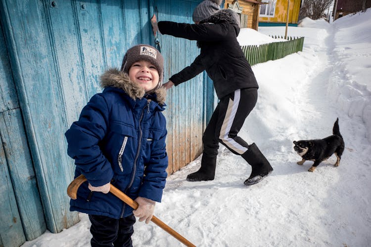 Children And Dog Near Shed In Winter