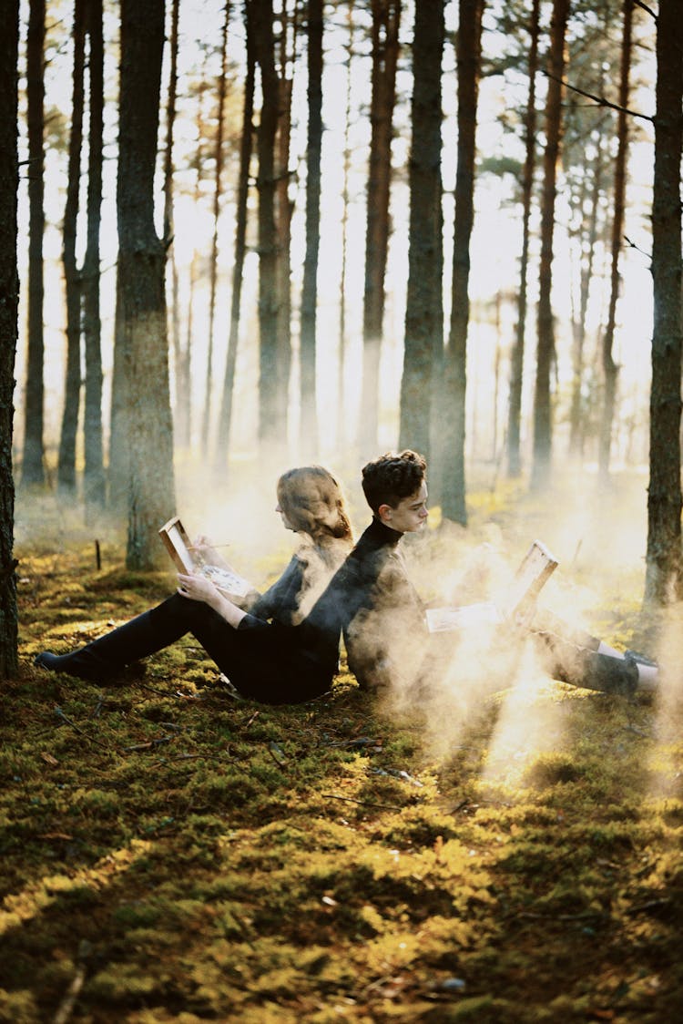 Couple Reading Books In Forest