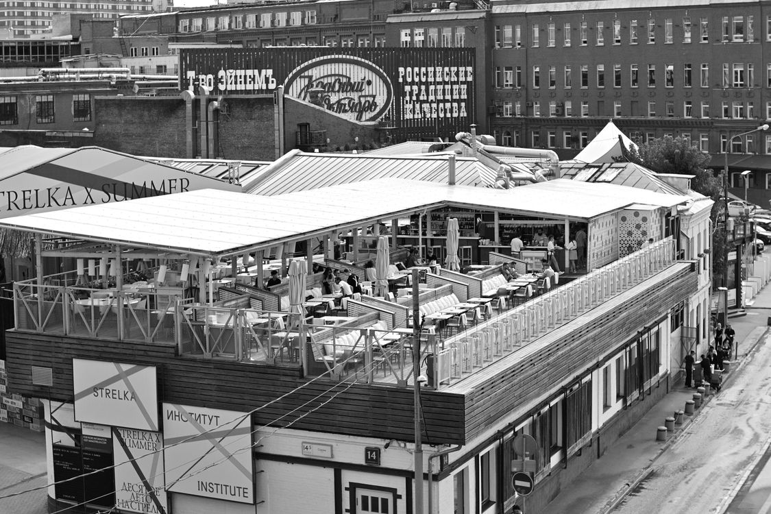 Free Black and white photo of a bustling rooftop restaurant in an urban setting. Stock Photo